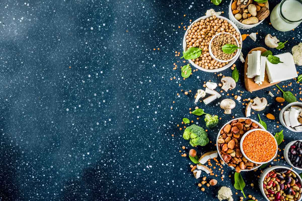 Una mesa con disferentes alimentos que son fuentes de proteina vegetal